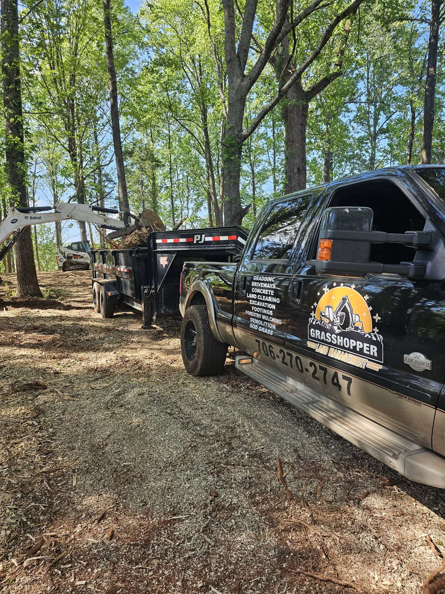 Grasshopper Land Management truck and equipment at a work site.