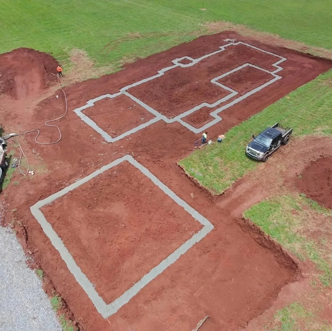 Concrete footings laid out across a prepared building site.